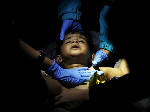 Médicos voluntários e paramédicos tentam reanimar um bebê depois que um barco que transportava mais de 200 refugiados naufragou durante a travessia do mar Egeu na Turquia até a ilha grega de Lesbos