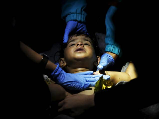 Médicos voluntários e paramédicos tentam reanimar um bebê depois que um barco que transportava mais de 200 refugiados naufragou durante a travessia do mar Egeu na Turquia até a ilha grega de Lesbos - 28/10/2015