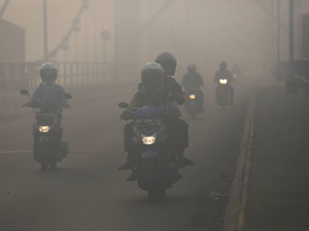 Motoristas dirigem sob forte neblina na cidade de Banjarmasin, Indonésia. A fumaça provocada pelos incêndios florestais criou uma névoa que atingiu grande parte do sudeste asiático nos últimos meses, deixando mais de 500 mil indonésios com problemas respiratórios - 28/10/2015