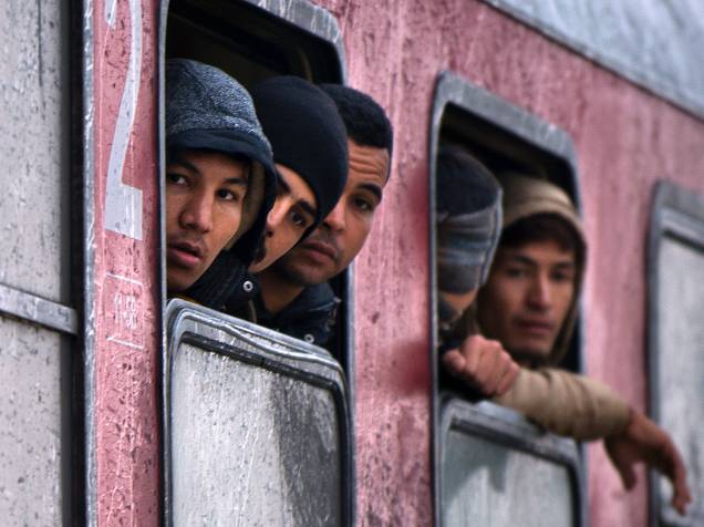 Imigrantes e refugiados olham pela janela de um trem partindo para a Sérvia. Mais de 700,000 refugiados chegaram às costas mediterrânicas da Europa ao longo deste ano, em meio à pior crise migratória desde a Segunda Guerra Mundial - 28/10/2015