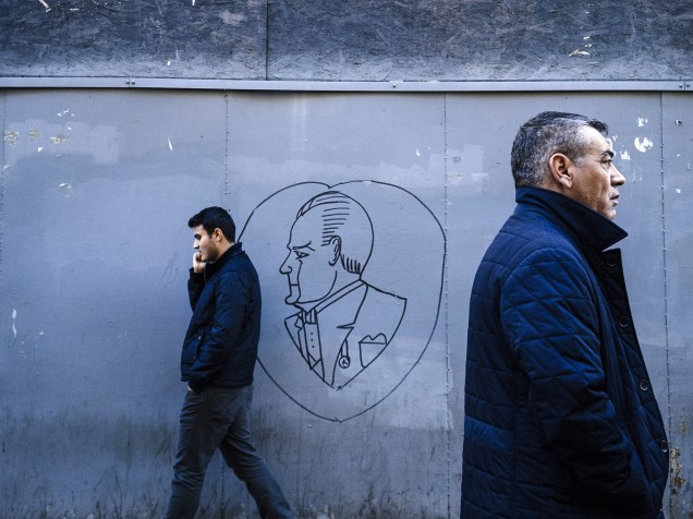 Homens caminham em frente a um desenho retratando o fundador da República da Turquia, Mustafa Kemal Ataturk, em Istambul, uma semana antes das eleições gerais do país em 1º de novembro. A votação foi programada depois que o Partido da Justiça e Desenvolvimento perdeu sua maioria nas eleições de junho e não conseguiu formar um governo de partilha de poder
