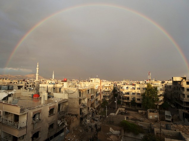 Arco-íris é visto sobre um local atingido por um ataque aéreo promovido por forças leais ao presidente sírio Bashar al-Assad, sobre o principal hospital de campanha do distrito de Douma, em Damasco