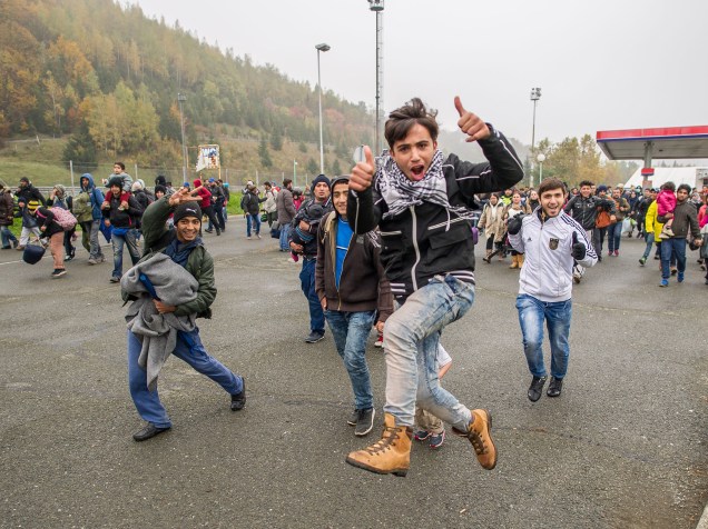 Refugiados correm para entrar na Áustria a partir da fronteira com a Eslovênia, na cidade de Sentilj