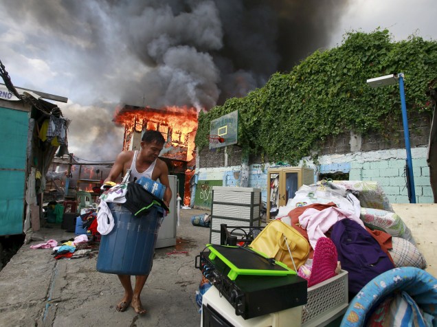 Morador retira seus pertences após incêndio em Tambo, cidade de Paranaque, ao sul de Manila. De acordo com a mídia local, pelo menos 150 famílias ficaram desabrigadas
