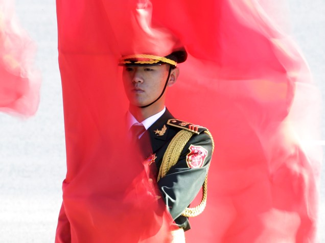Soldado da guarda de honra chinesa, segura uma bandeira durante cerimônia de boas vindas para a chanceler alemã Angela Merkel, em Pequim