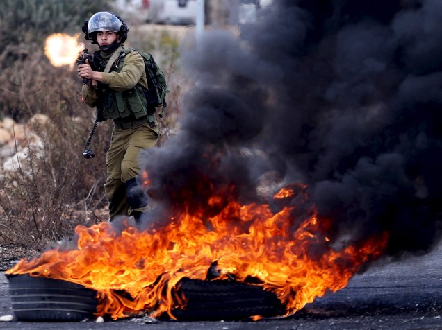 Soldado israelense atira em manifestantes palestinos durante confrontos perto de Ramallah, na Cisjordânia. Um palestino foi baleado após atacar israelenses com uma faca aumentando a tensão em Jerusalem - 30/10/2015