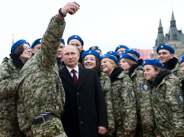Jovens ativistas fazem selfie com o presidente russo, Vladimir Putin (ao centro), na praça Vermelha, em Moscou, durante as celebrações do Dia da Unidade Nacional. A data comemora o 403º aniversário da expulsão das forças de ocupação polonesas do Kremlin em 1612