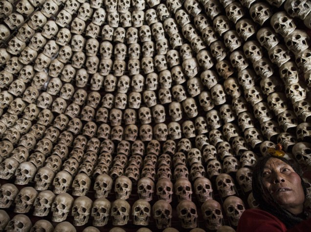 Tibetana em uma sala para enterros, decorada com crânios humanos falsos, perto do vale Larung localizado a cerca de 3700 metros acima do nível do mar