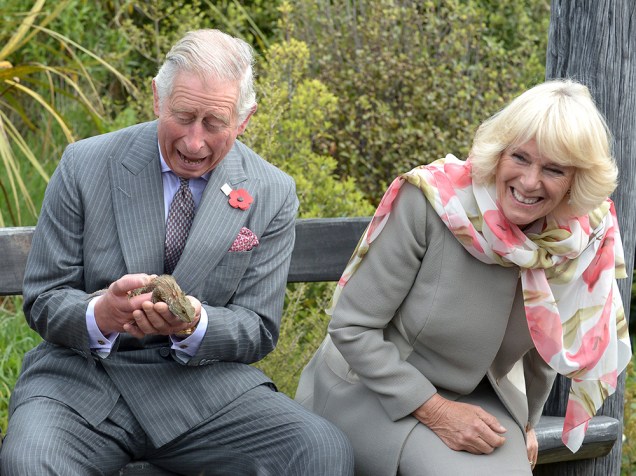 O príncipe Charles segura um lagarto tuatara durante uma visita ao santuário Orokonui Eco, perto de Dunedin, na Nova Zelândia