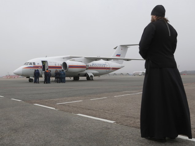 Sacerdote ortodoxo observa a chegada dos corpos de vítimas do acidente com um avião de passageiros russo que caiu no Egito, no aeroporto de Pulkovo, em São Petersburgo, na Rússia - 06/11/2015