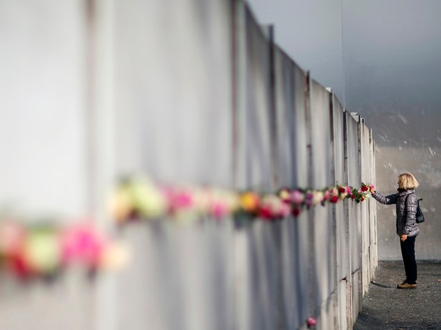 Mulher coloca rosas no Memorial do Muro de Berlim, após cerimônia de aniversário de 26 anos da queda do muro, em Berlim, Alemanha - 09/11/2015