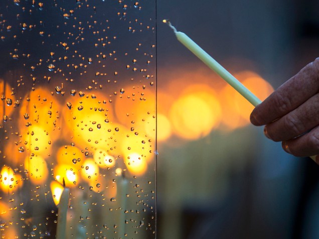 Idosa acende uma vela após cerimônia que marcou o 26º aniversário da queda do Muro em Berlim, na Alemanha - 09/11/2015