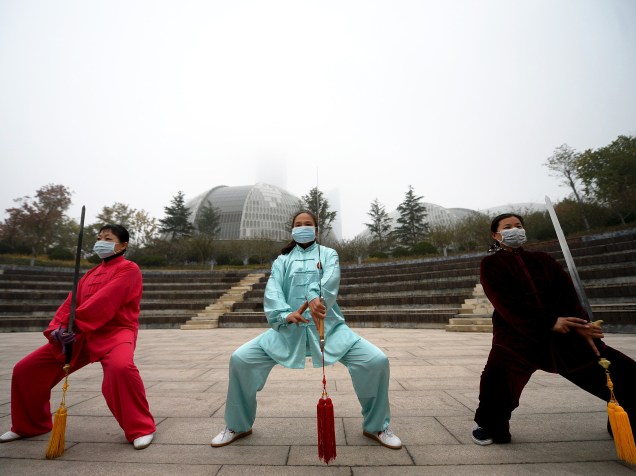 Enquanto praticam exercício, chineses usam máscara para se proteger da imensa poluição que atingiu Jinan, província de Shandong nesta manhã - 10/11/2015