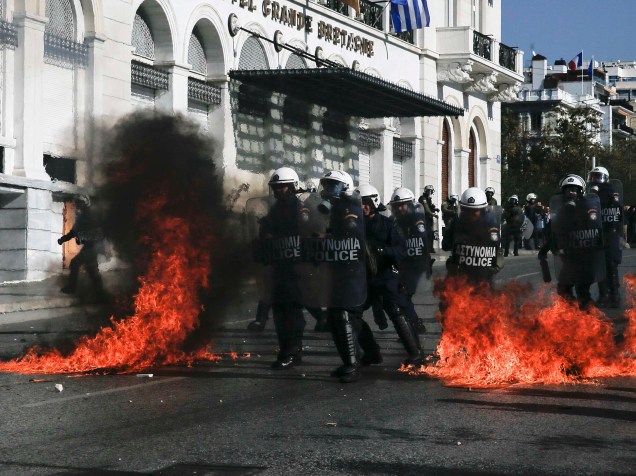 Polícia de choque caminha entre as chamas durante confronto com manifestantes em uma greve geral no centro de Atenas, Grécia, devido a medidas de austeridade exigidas por credores internacionais em troca de fundos de resgate - 12/11/2015