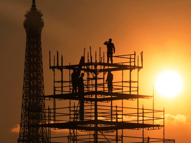 Silhueta de trabalhadores é vista ao lado da Torre Eiffel durante pôr do sol em Paris, França - 13/11/2015