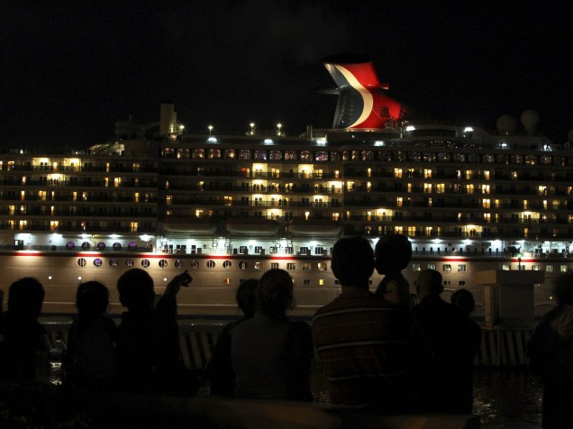 Pessoas assistem a passagem do transatlântico Carnival Miracle que deixava o porto de Mazatlan, no México - 25/11/2015