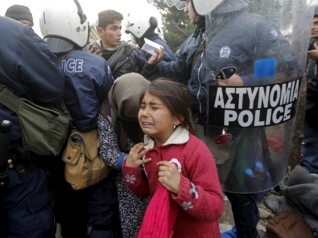 Menina refugiada chora depois de passar por um cordão policial antes de atravessar a fronteira greco-macedônia perto da aldeia de Idomeni, na Grécia - 04/12/2015