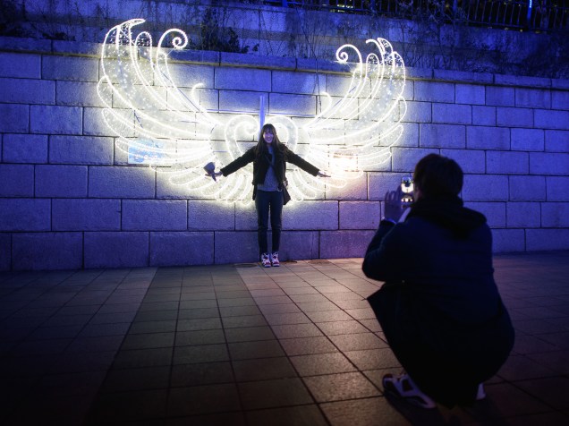 Mulher posa para foto em meio à decorações de Natal no centro de Seul, Coreia do Sul - 17/12/2015