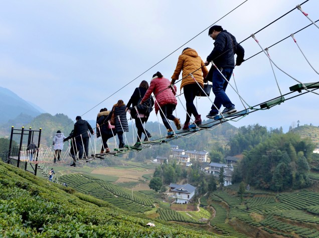 Turistas andam por cima de uma plantação de chá em Enshi, na província de Hubei, China - 28/12/2015