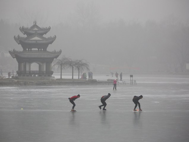 Pessoas patinam em um lago no Parque de Taoranting durante um dia nebuloso em Pequim, na China - 28/12/2015