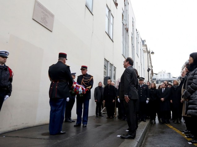 O presidente francês, François Hollande, participa de uma homenagem em frente ao antigo escritório do semanal satírico Charlie Hebdo em Paris. O local foi alvo de um ataque a tiros em janeiro de 2015