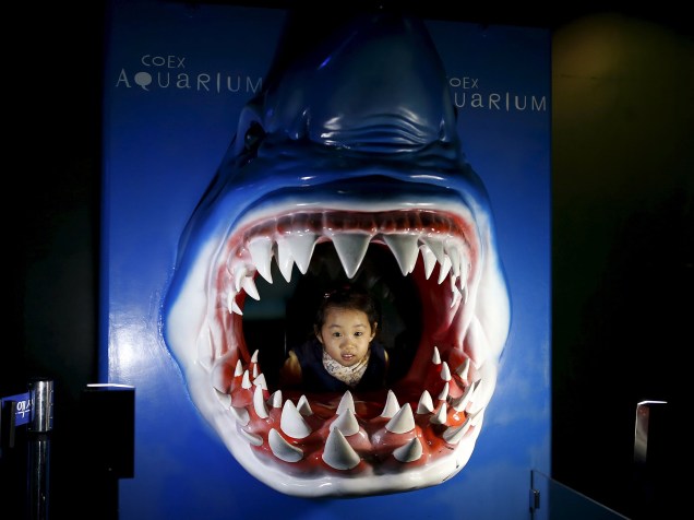 Menina posa para fotos dentro de uma escultura em forma de tubarão no aquário de Seoul, na Coreia do Sul - 12/01/2016