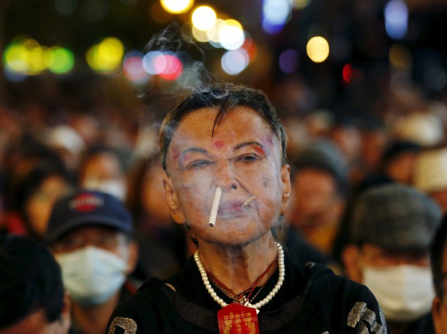 Eleitora fuma um cigarro durante evento de campanha eleitoral à frente das eleições em Taipei, na capital de Taiwan, nesta quinta-feira (14)