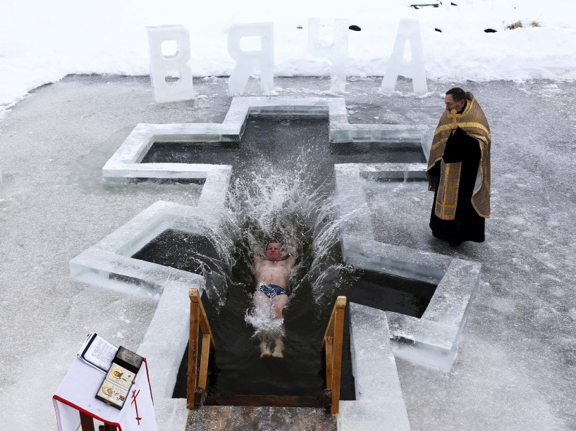 Homem mergulha nas águas geladas de um lago durante as celebrações da Epifania Ortodoxa em Minsk, na Bielorrússia - 18/01/2016