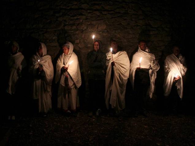 Etíopes ortodoxos seguram velas enquanto fazem orações durante a celebração do Timket que comemora o batismo de Jesus Cristo por João Batista no rio Jordão, em Gondar, Etiópia