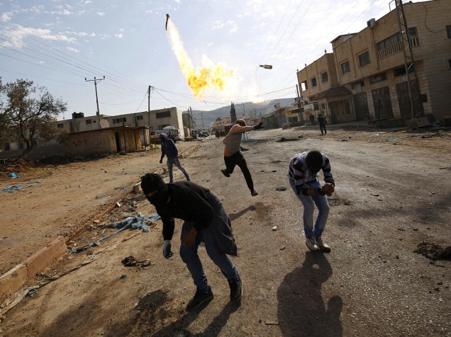 Manifestante palestino arremessa coquetel molotov, em direção às tropas israelenses, durante confronto na Cisjordânia