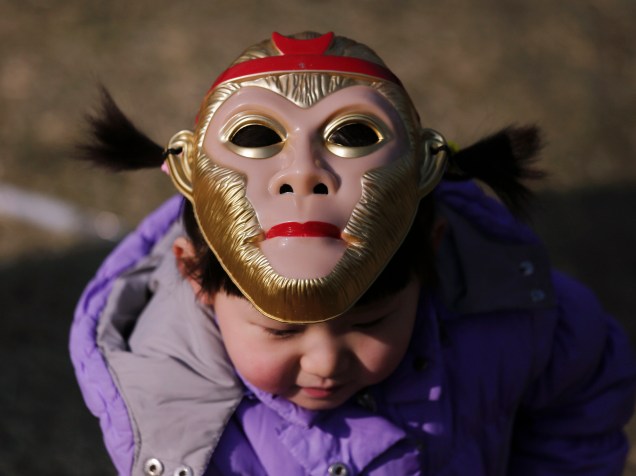 Menina com máscara de macaco, em sua cabeça, no Parque de Longtan, para dar boas vindas ao ano novo chinês, em Beijing, na China