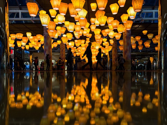 Pessoas andando sobre lanternas em exposição em um shopping center, em celebraçāo ao Ano Novo chinês, em Hong Kong, na China