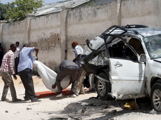 Familiares removem de um carro destruído o corpo de Mohoyadiin Mohamed Haji, conselheiro político do Parlamento da Somália, morto em Mogadíscio num ataque com bomba, segundo as autoridades