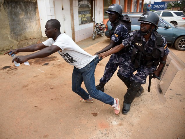 Policiais de Uganda algemam manifestante na capital do país, Kampala. Eleitores insatisfeitos com a demora na apuração e com o resultado final protestaram, e a polícia interveio com gás lacrimogêneo
