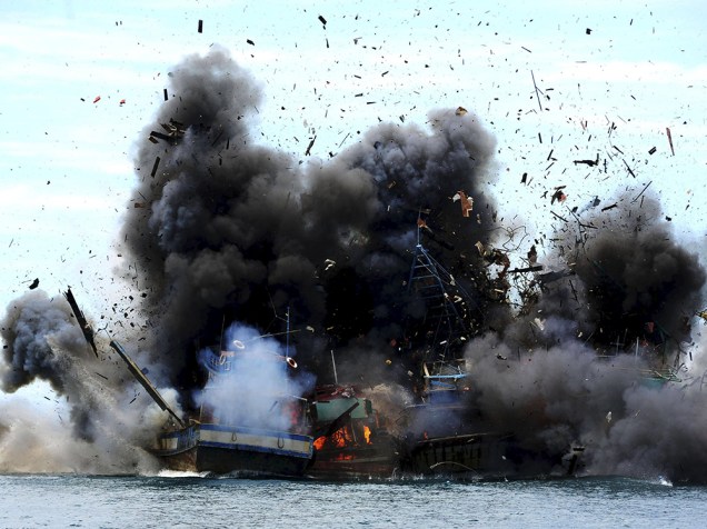 Barco de pesca é atingido por armas do governo indonésio em Batam. A Indonésia afundou 27 barcos estrangeiros apreendidos em 22 de fevereiro, em uma intensa campanha contra a pesca ilegal