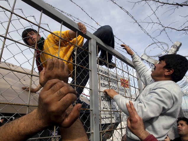 Imigrante em cerca na fronteira da Grécia com a Macedônia, depois da Macedônia fechar suas fronteiras, próximo à aldeia de Idomeni, nesta segunda-feira (22)