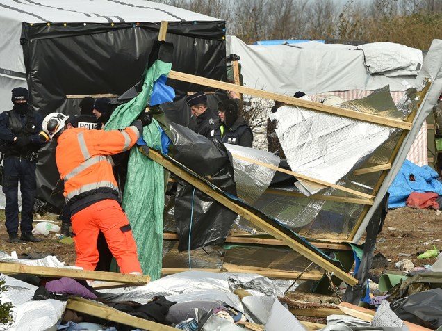 Agentes desmontam um acampamento de refugiados em Calais, norte da França. Um tribunal francês autorizou a retirada de centenas de imigrantes da cidade portuária, que tentam entrar no Reino Unido, através do canal da Mancha