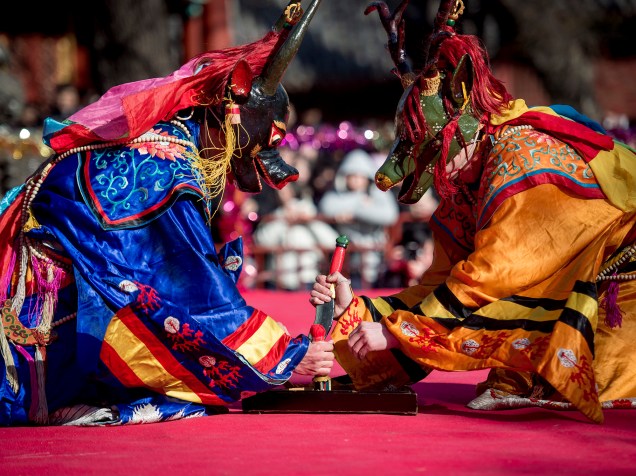 Monges budistas tibetanos vestidos de monstros participam de uma celebração religiosa durante festival em Pequim, na China