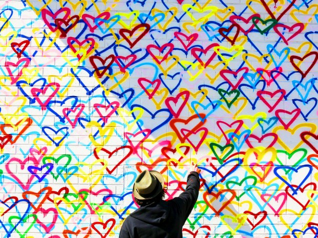 Artista grafita parede com spray, durante visita da primeira-dama dos Estados Unidos, Michelle Obama, no Union Market, em evento de comemoração ao Dia Internacional da Mulher, nesta terça-feira (08)