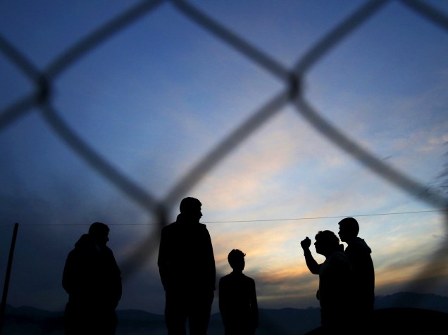 Refugiados aguardam para atravessar a fronteira entre a Grécia e a Macedônia, nesta terça-feira (08)