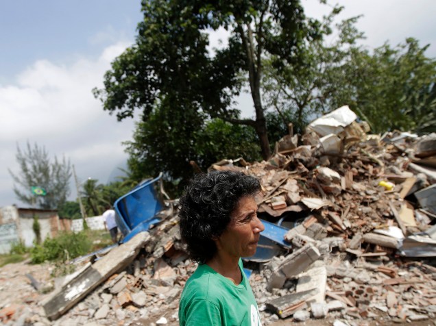 Uma mulher passa em frente aos escombros de uma casa demolida na comunidade Vila Autódromo, no Rio de Janeiro, cercado por obras do Parque Olímpico do Rio, onde algumas famílias ainda lutam contra o despejo