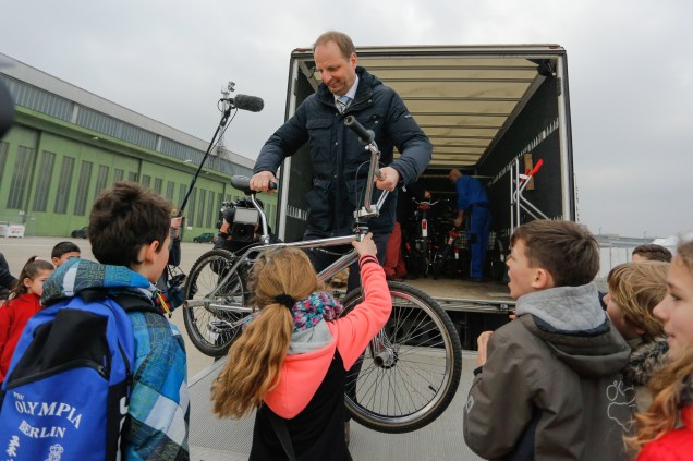 Crianças recebem bicicletas doadas em acampamento de refugiados em Tempelhofer Flughafen, na Alemanha, na manhã desta quinta-feira (10)