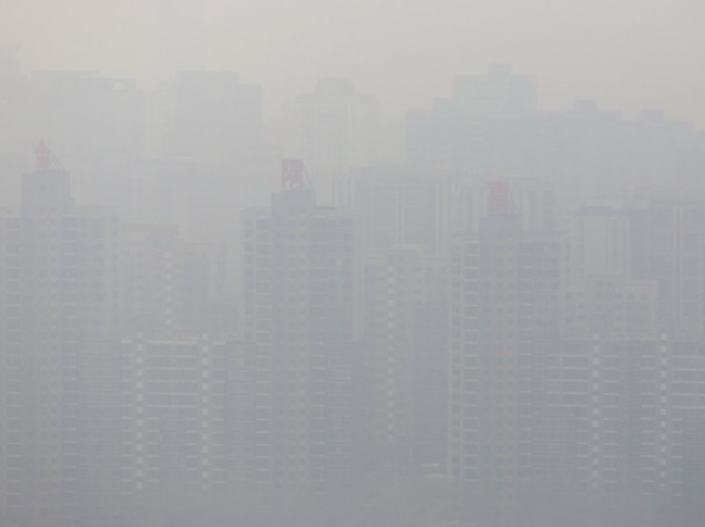 Prédios em Pequim são encobertos por névoa causada pela poluição na capital chinesa, nesta quarta-feira (16)