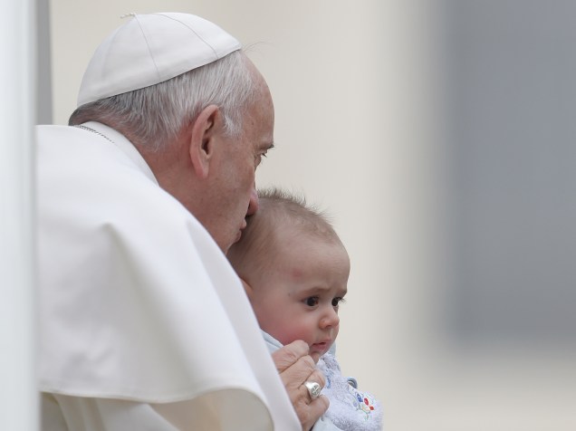 O papa Francisco beija uma criança antes de sua audiência semanal na praça São Pedro, no Vaticano, na manhã desta quarta-feira (16)