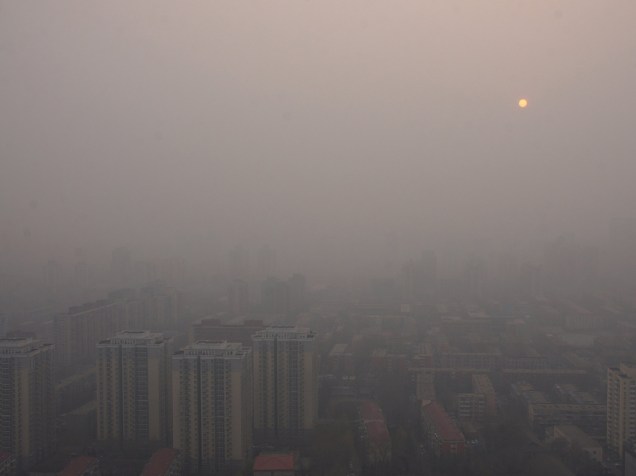 Prédios em Pequim são encobertos por névoa causada pela poluição na capital chinesa, nesta quinta-feira (17)