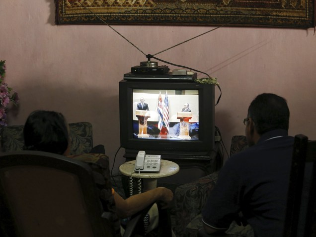 Casal assiste à conferência em que o Presidente dos Estados Unidos Barack Obama e o cubano Raul Castro discursaram, em Havana