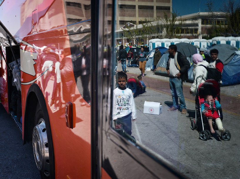 Família de refugiados da Síria aguardam ônibus que partem do Porto de Piraeus para outros acampamentos de refugiados, na Grécia, com objetivo de liberar o porto para que as atividades comerciais sejam retomadas normalmente - 31/03/2016