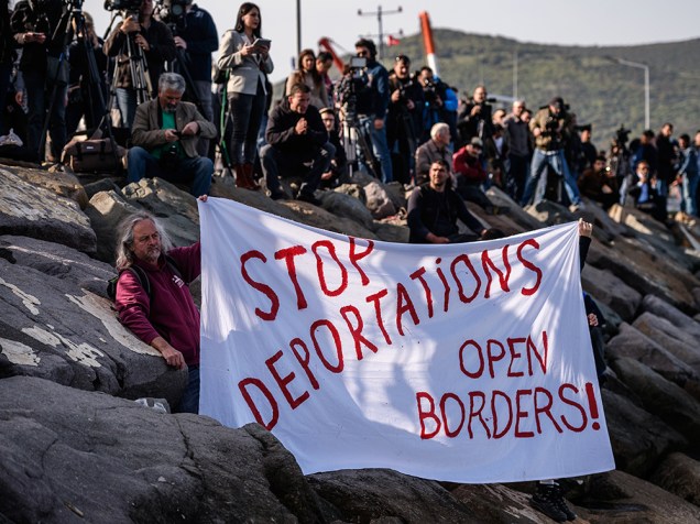Ativistas na Alemanha protestam contra a deportação de refugiados da Grécia para a Turquia e levantam cartaz que diz, em tradução livre, "Parem com a deportação, abram as fronteiras" - 04/04/2016