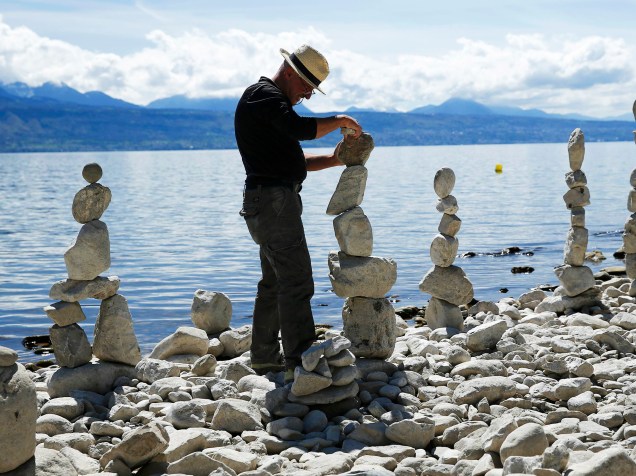 O artista suiço Daniel Dunkel constrói um monte com pedras, no Lago Leman, próximo à cidade de Lausanne, na Suiça - 14/04/2016