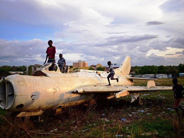 Crianças brincam em um avião de combate destruído em Juba, no Sudão do Sul - 21/04/2016